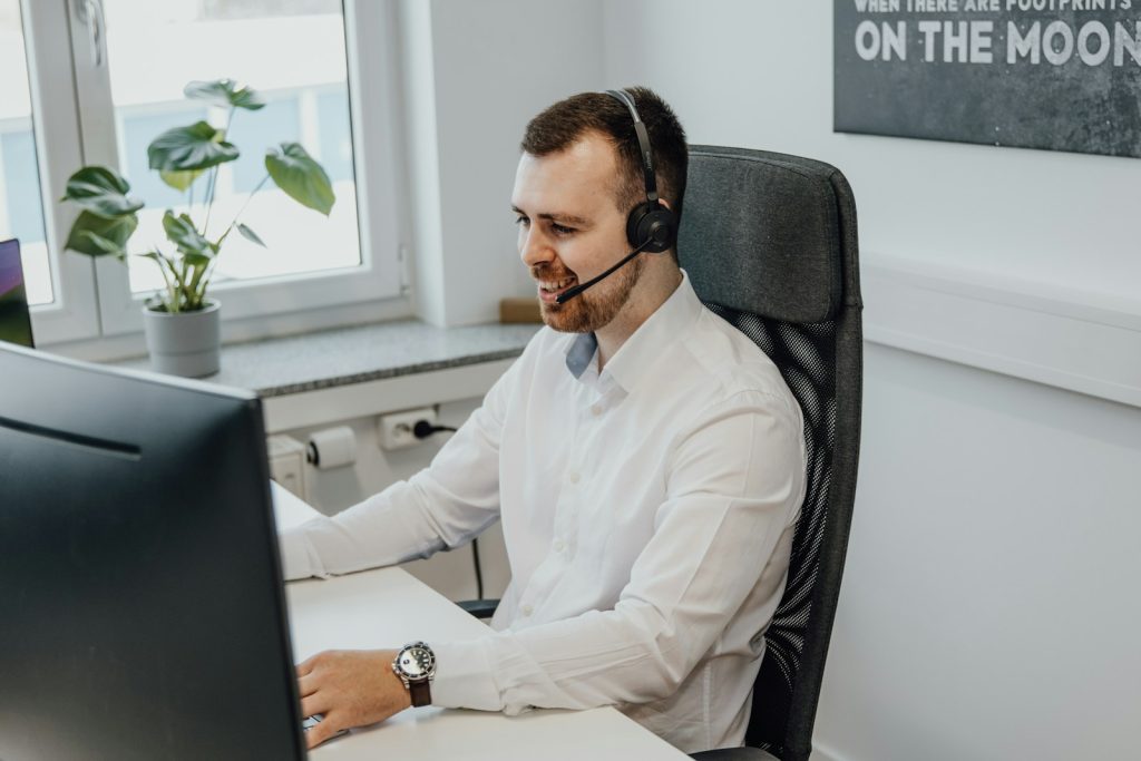 un homme portant un casque, assis devant un ordinateur